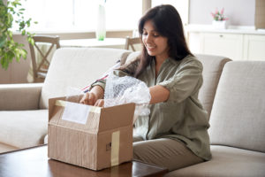 Smiling,Indian,Woman,Shopper,Customer,Opening,Post,Package,Box,Sitting